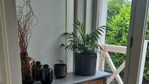 A room with a grey console table, a potted plant, and a wicker basket. - 1st line water front 5 Minutes to the beach and 10 mins to old town center. (Hellevoetsluis)