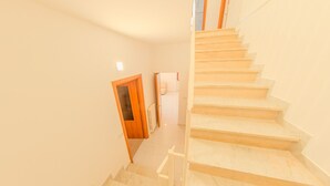 A staircase leading to a landing with a wooden door and a radiator. - The Stars - Frigento (Frigento)