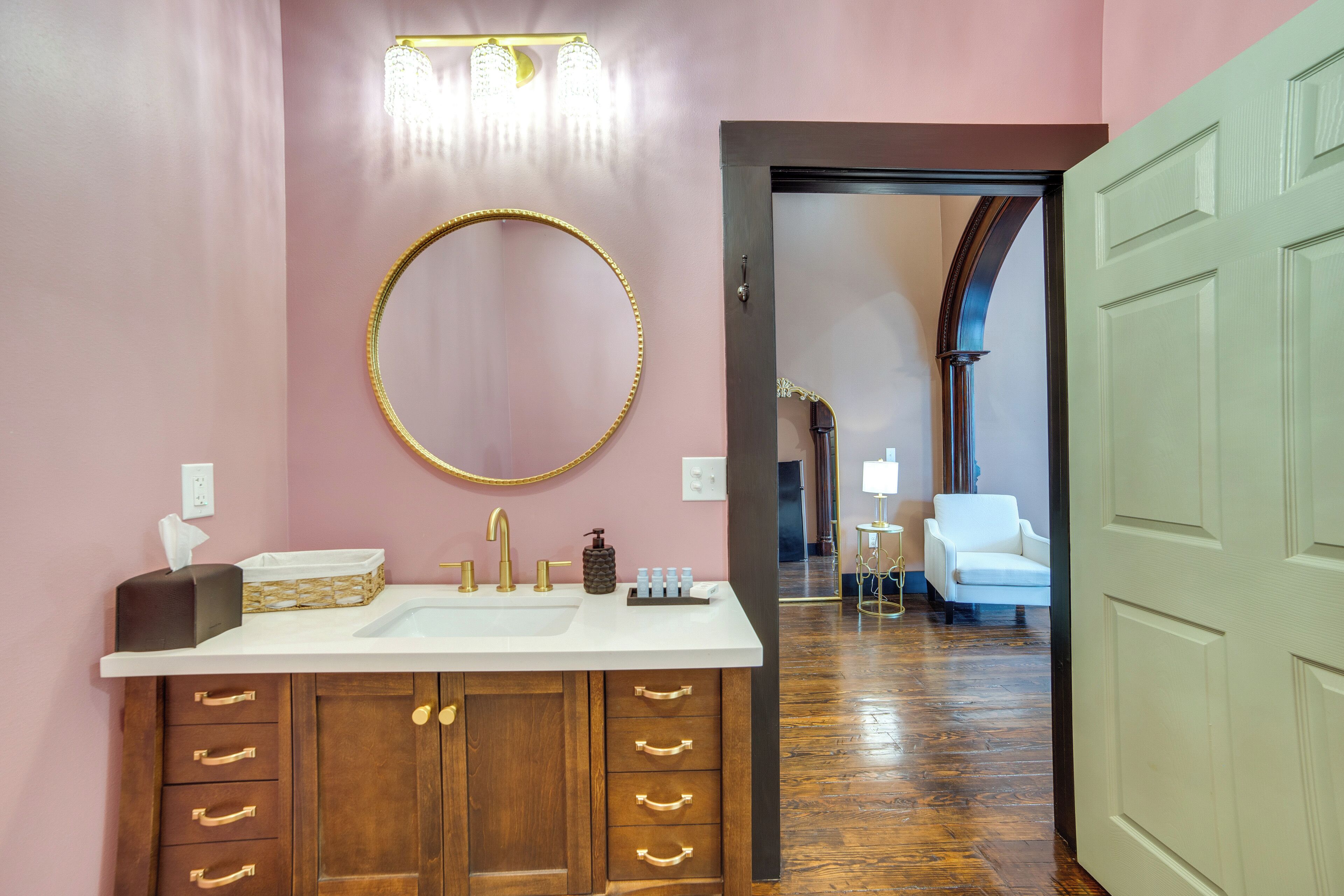 A bathroom with a large mirror, a vanity with a sink, and a wooden cabinet with drawers.