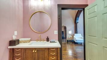 A bathroom with a large mirror, a vanity with a sink, and a wooden cabinet with drawers.