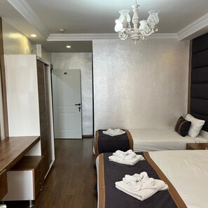 Hotelkamer met een bed, nachtkastjes, een bureau, een stoel, een kledingkast en een kroonluchter.