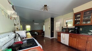 A spacious kitchen with wooden cabinets, a large island, and a dining area in the background.