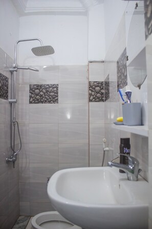 Een haardroger, handdoeken, zeep, toiletpapier