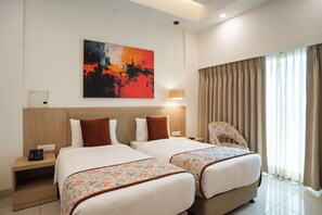 A hotel room with two beds, a large abstract painting on the wall, a bedside lamp, and a view of the outdoors through sheer curtains. - AR Suites KLJ Square (Gurugram)
