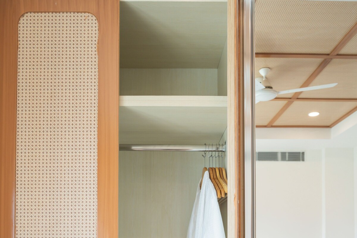 A hotel room with a bed, a wardrobe, and a bathroom.