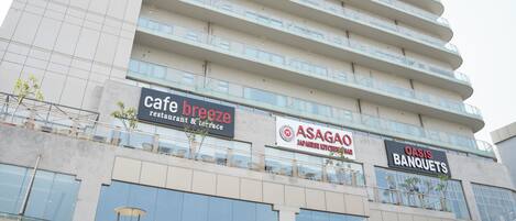 Un edificio de varios pisos con diversos comercios, incluyendo una cafetería, un restaurante japonés y un salón de banquetes.