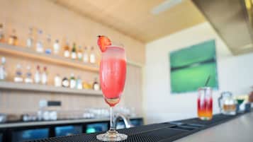 Un bar con una copa de cóctel adornada con una fresa sobre la barra.