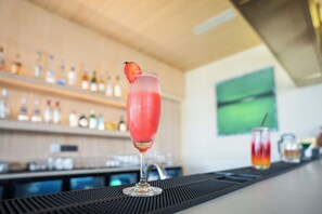 Un bar con una copa de cóctel adornada con una fresa sobre la barra.