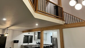 A modern kitchen with white cabinets, a central island, and a dining area with a table and chairs.