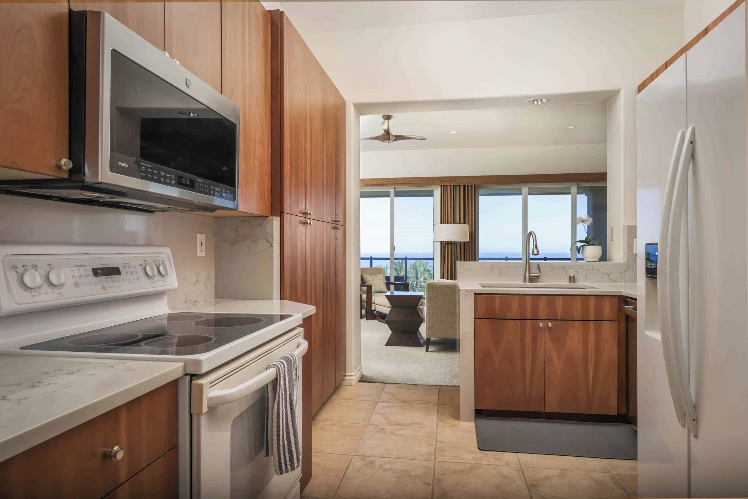 Una cocina moderna con gabinetes de madera, un microondas integrado, una estufa y un refrigerador.