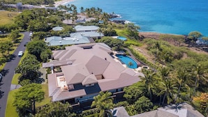 Une propriété située sur la côte, comprenant plusieurs bâtiments, une piscine et offrant une vue sur l’océan.