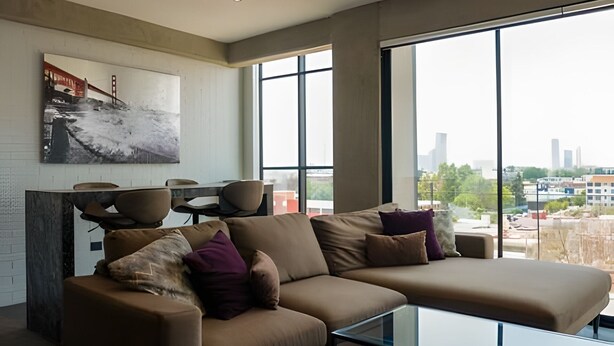 A modern living room with a large window, a sofa, and a dining area. - Apartment with Beautiful Views | ACASO 502 (Heroica Puebla de Zaragoza)