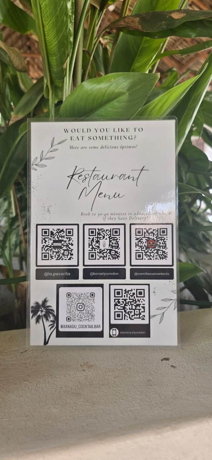 A menu board with QR codes and social media handles for a restaurant.