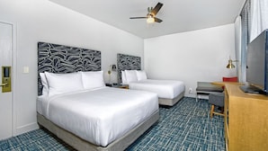 A hotel room with two beds, a desk, a television, and a ceiling fan. - Relaxing Double Room with Rooftop Pool, Near Pier 39 & Coit Tower (San Francisco)