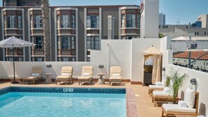 A rooftop pool with lounge chairs and a view of a modern building. - 2 Family-Friendly Units Cozy Room, Steps to Yerba Buena & Rooftop Pool in SF (San Francisco)