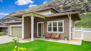 A two-story house with a covered porch, a garage, and a well-maintained lawn.