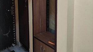 Une pièce avec une armoire, une porte et un sol carrelé.