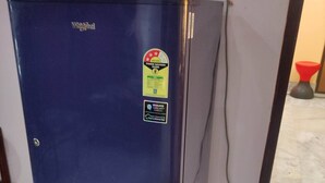 Un réfrigérateur bleu, muni d’un autocollant indiquant des conseils pour économiser l’énergie et d’une étiquette isolante pour le capillaire.
