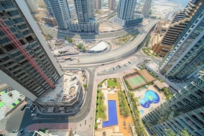 A high-rise building with a rooftop pool and a children's play area. - Marina Tower 2602 (Dubai)