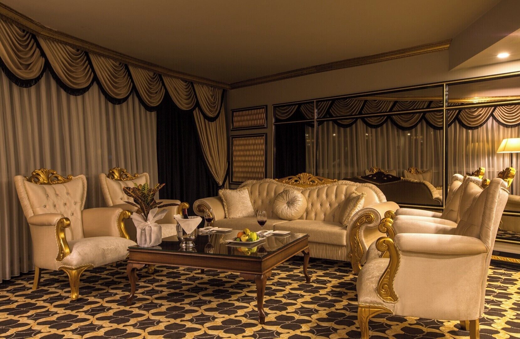 A luxurious living room with a patterned floor, elegant furniture, and draped curtains.