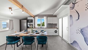 Una cocina moderna con comedor, ventanas amplias y vistas al exterior.