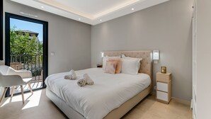 A modern bedroom with a large bed, a bedside table, and a view of the outdoors. - Luxury appartement avec parking (Saint-Tropez)
