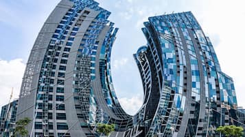 A modern building with a unique curved design, featuring multiple glass windows and a reflective facade.