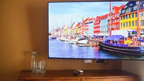 A television displaying a colorful harbor scene with boats and buildings. - Selanna 3 Luna Creciente (El Paredon)