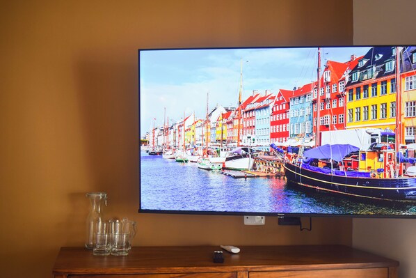 Un televisor muestra una escena colorida de un puerto con barcos y edificios.