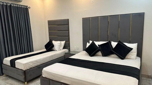 Ein Hotelzimmer mit zwei Betten, modernem Design und einem großen Fenster.