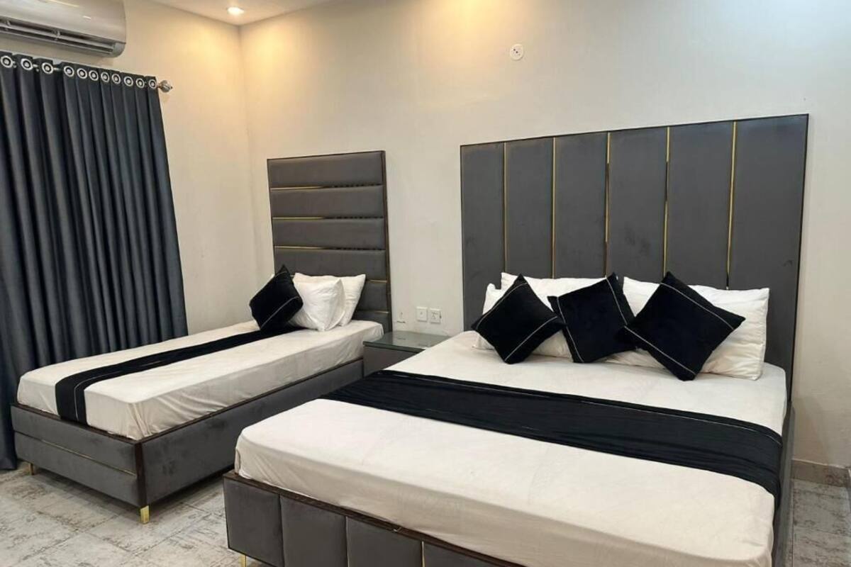 Habitación de hotel con dos camas, diseño moderno y ventana grande.