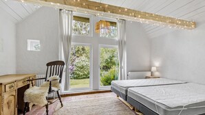 A bedroom with a large window, a wooden desk, a chair, a bed, and a bedside lamp. - 5 bedroom cozy home in ørsted (Ørsted)