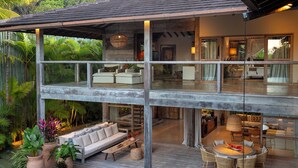 A multi-level house with a wooden deck, outdoor seating, and a dining area. - Your luxury home in the heart of Trancoso (Trancoso)