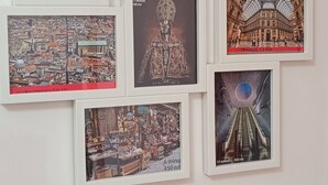 Una serie de fotografías enmarcadas que muestran diferentes escenas arquitectónicas y culturales, incluyendo un edificio histórico, una estatua, un mercado y una obra de arte con temática espacial.