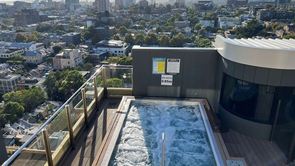 Un spa situé sur le toit, d’une profondeur de 0,85 mètre, entouré d’une balustrade en verre et offrant une vue panoramique sur la ville.