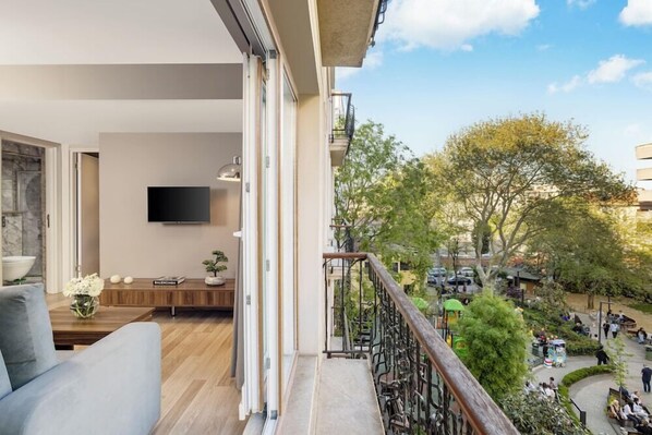 A modern living room with a sofa, a flat-screen TV, and a wooden bench. - Home Suite Home Nisantasi (Istanbul)