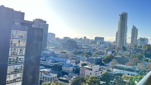 A cityscape with modern high-rise buildings, a mix of residential and commercial structures, and a clear sky.