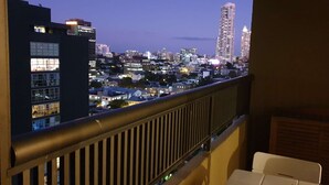 A balcony with a view of a cityscape at dusk, featuring various buildings and a railing. - Large City Studio with Big Balcony (Darlinghurst)