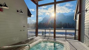A hot tub with a view of mountains and a clear sky.