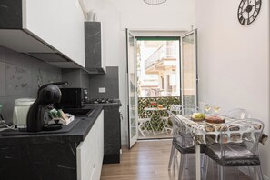 Une cuisine moderne dotée d’un plan de travail en marbre noir, d’une cuisinière et d’un coin repas avec une table et des chaises.