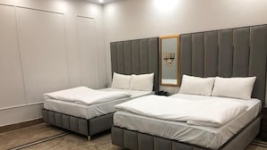 A hotel room with two beds, a large mirror, and a chandelier. - Five Seasons Hotel Lahore (Lahore)