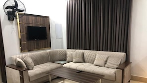 A L-shaped sectional sofa with a dark wooden coffee table in front. - Five Seasons Hotel Lahore (Lahore)
