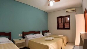 A hotel room with three beds, a ceiling fan, a window with blinds, and a TV mounted on the wall. - Hotel Ricci  (Batatais)