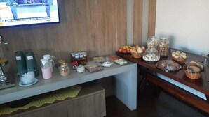 A buffet setup with various food items and beverages. - Hotel Ricci  (Batatais)