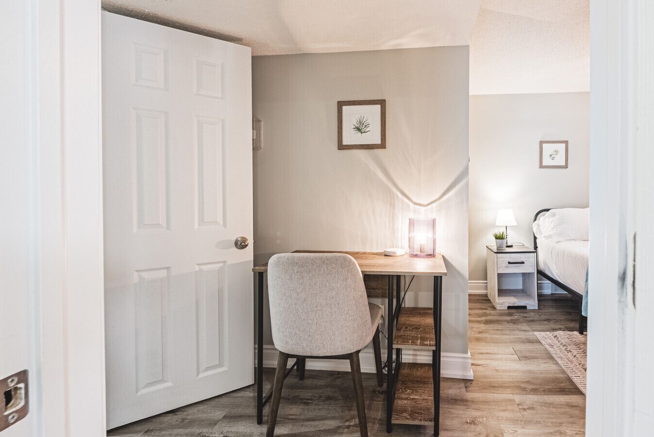 Une chambre à coucher comprenant un lit, une table de chevet, une lampe et un petit bureau avec une chaise.