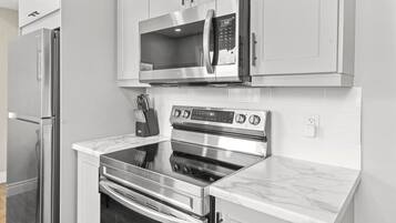 Una cucina moderna con elettrodomestici in acciaio inossidabile, tra cui un forno a microonde, forno e frigorifero.
