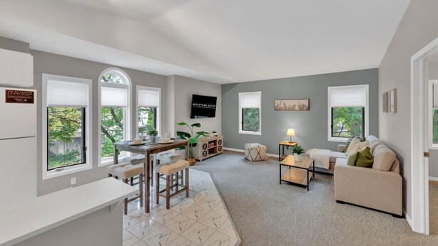 A spacious living area with a kitchen, dining area, and seating space. - Cozy & Comfortable, Downtown, Parking | TJSI (Burlington)