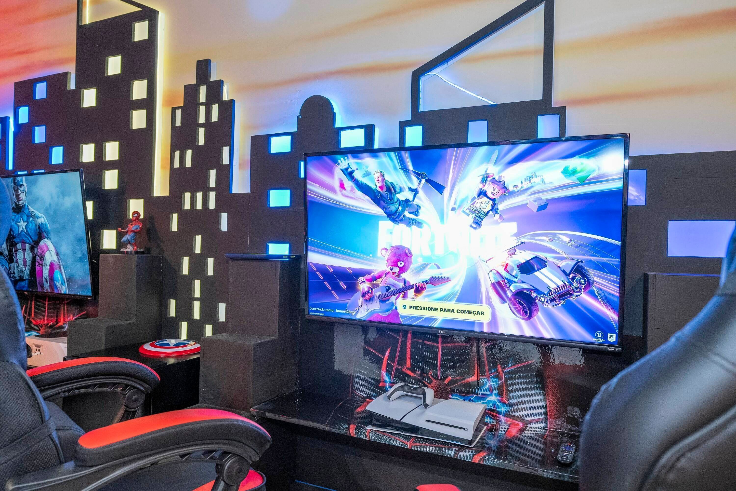 En gaming-opsætning med flere skærme, et racerspil på skærmen og en gamerstol med biltema.