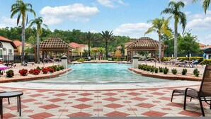A pool area with two gazebos, palm trees, and lounge chairs. - Spacious 12br Family Villa Near Disney Bella Vida (Kissimmee)