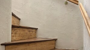 Eine Holztreppe mit Handlauf und einer Wand mit einem Blumenmuster.